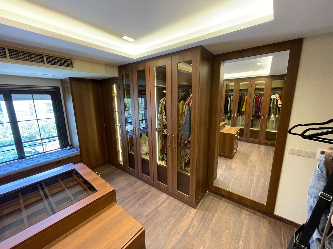 Dressing room with full-length mirror and lit wardrobes
