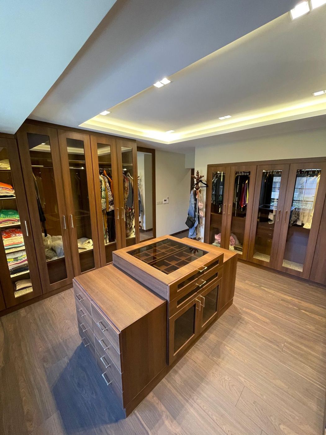 Walk-in wardrobe with LED-lit glass doors