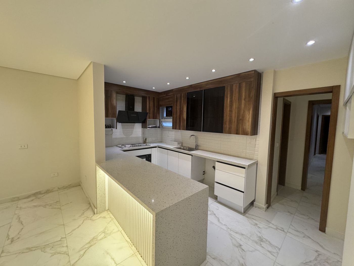 White and walnut kitchen with lit peninsula